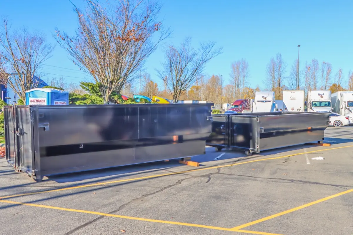 Professional dumpster rental service with roll-off container on residential driveway in Rusk